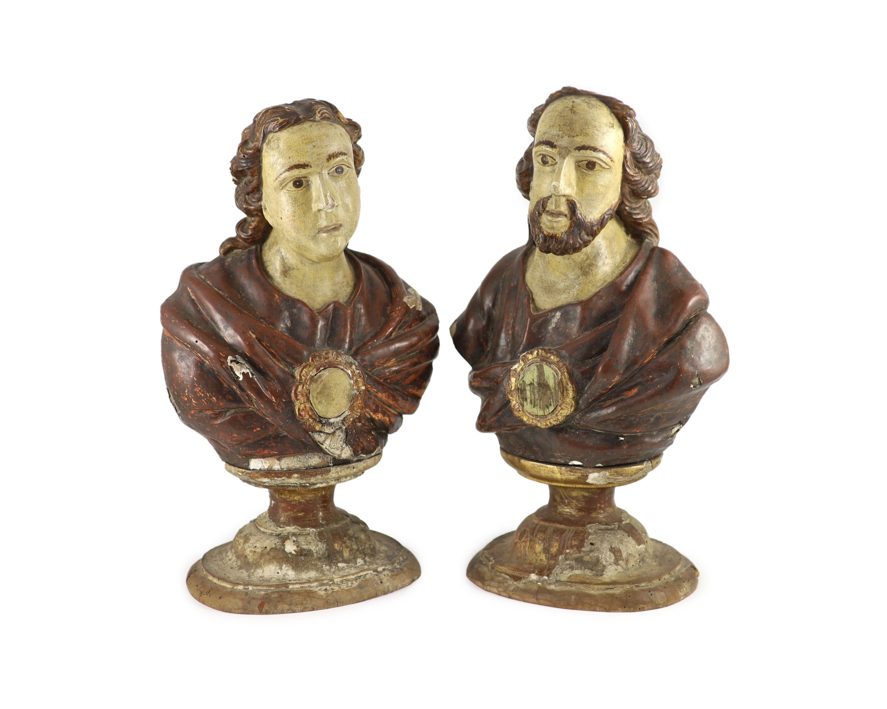 A pair of early 19th century Spanish carved and painted busts of saints, width 25cm approx. height 44cm